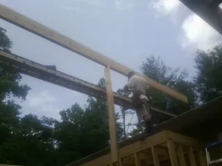 Carpenter setting a ridge beam over a new addition frame — Ice Dam Removal by Roofing Brothers in Woolwich